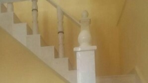 A staircase with white balusters and a handrail, leading to a landing. - Hostal En Casa (Bayamo)