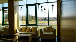 Un hall d’entrée moderne avec de grandes fenêtres, un ensemble de canapés et une table basse.