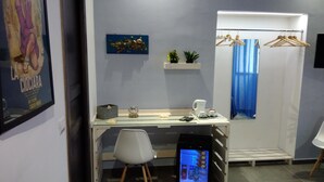 A hotel room with a desk, chair, shower area, and a television displaying a movie. - B&B Napoli Culture (Naples)