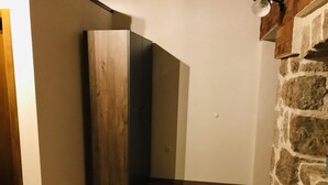 A corner room with a wooden wardrobe, a stone wall, and a wooden floor. - Holiday Home Ante is set in Starigrad Paklenica. (Starigrad Paklenica)