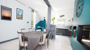Une cuisine moderne avec un mur d’accent de couleur turquoise, une horloge et un panneau indiquant qu’on y sert du café.