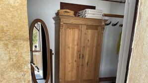 Un armario de madera con espejo y puerta.