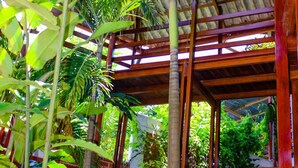 A wooden structure with a thatched roof surrounded by lush tropical vegetation. - Hotel Rio Huallaga (Yurimaguas)