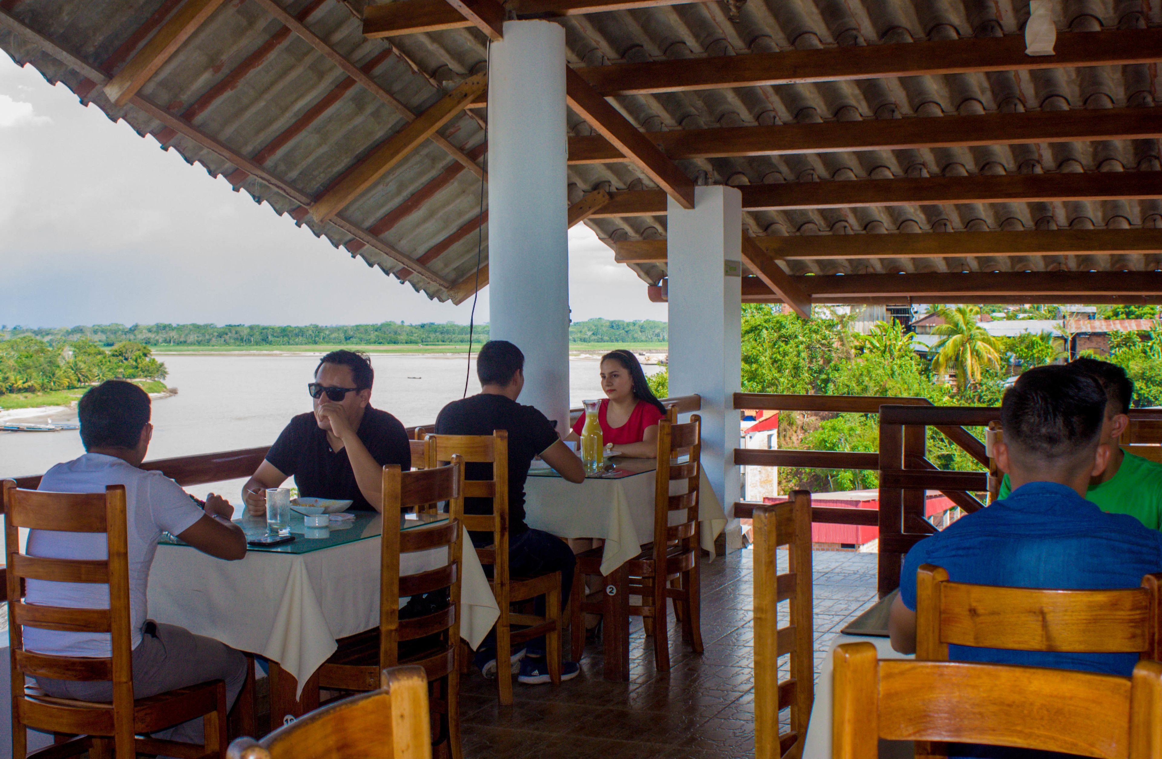 A restaurant with outdoor seating overlooking a body of water.