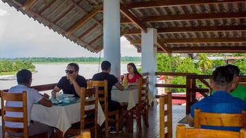A restaurant with outdoor seating overlooking a body of water.