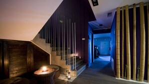 A modern staircase with a wooden handrail and a dark wall. - Hotel Warmia Spa (Braniewo)