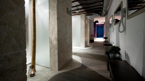 A hallway with stone walls, a wooden column, and a bench. - Hotel Warmia Spa (Braniewo)