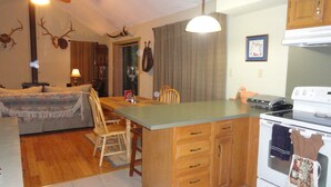 Una cocina acogedora con una mesa de comedor, armarios de madera y una estufa.