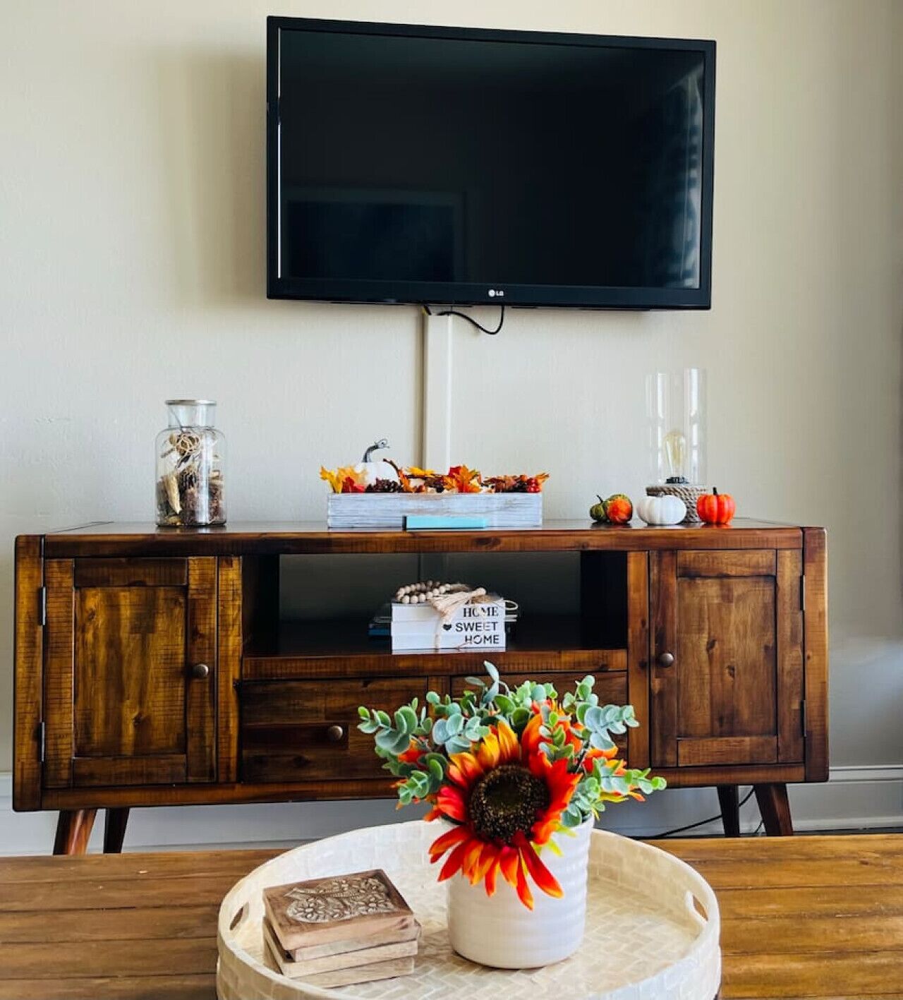 A wooden cabinet with a flat-screen TV mounted above it.