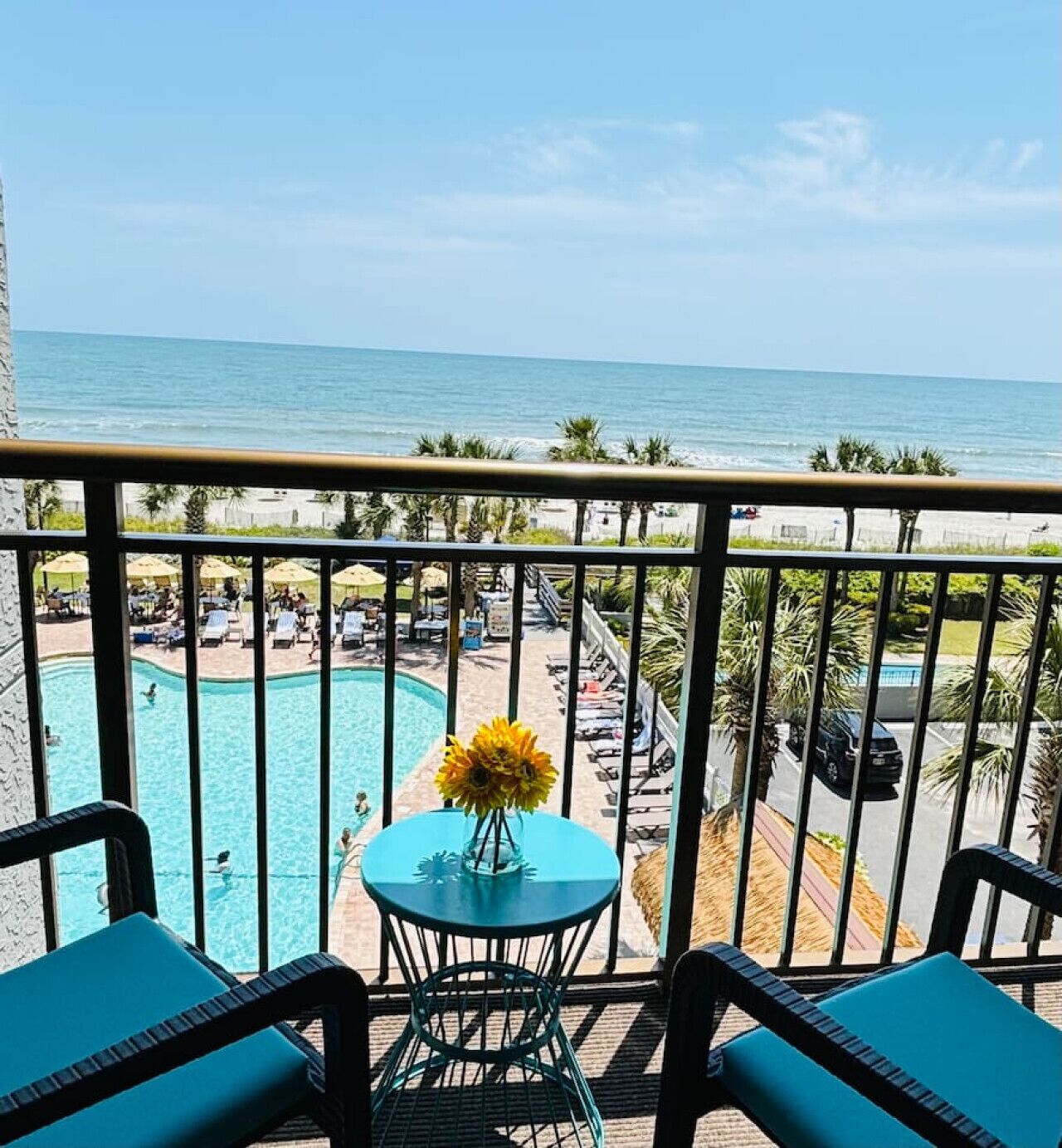 Un balcone con vista sulla piscina e sulla spiaggia.