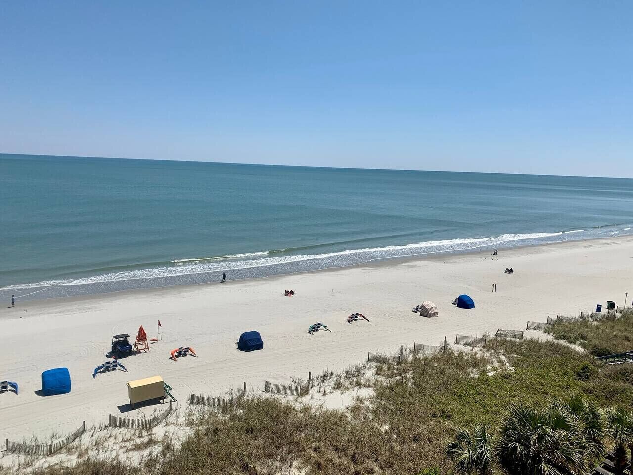 A beach with tents and beach chairs.
