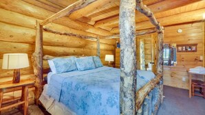 Un dormitorio tipo cabaña de troncos con una cama con dosel, paredes de madera y techo rústico.
