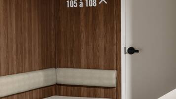 A modern room with a wooden panel wall, a bench, and a door marked with "105 à 108".