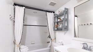 A bathroom with a bathtub, toilet, and sink.