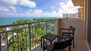 Ein Balkon mit Blick auf das Meer und Palmen.