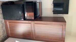 Une cuisine équipée d’un four à micro-ondes, d’un four traditionnel et d’un téléviseur fixé au mur.