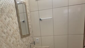 A bathroom with a toilet, sink, and mirror.