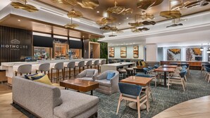 Un salón moderno con asientos de bar, mesas y una zona de bar.