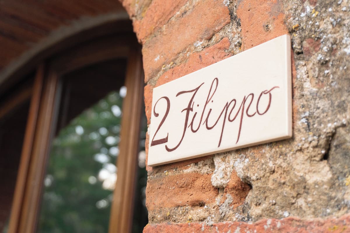 A sign with the number "2" and the word "Filippo" on a brick wall.