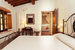 A bedroom with a bed, a desk, a chair, a mirror, and a small table with a lamp. - Borgo Rapale (Bucine)