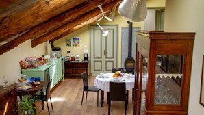 Un rincón comedor acogedor con vigas de madera, un armario verde y una mesa dispuesta para una comida.
