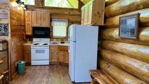A log cabin kitchen with wooden cabinets, a white stove, a microwave, and a refrigerator. - Elkmont Views - 1BR/New Hot Tub/New Firepit/Grill/Sleeps 6 (Gatlinburg)
