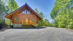A log cabin with a wooden staircase leading to a porch, surrounded by trees. - LeConte - 2BR/New Hot Tub/New Firepit/Grill/Sleeps 8 (Gatlinburg)