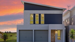 A modern two-story house with a garage, large windows, and a flat roof. - Time Away - 50 Turnberry Drive (Normanville)