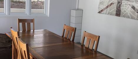 A dining area with a wooden table and chairs, a ceiling fan, and a map on the wall.