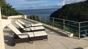 A terrace with lounge chairs and a view of the sea. - Famous Marigot Bay Ridge - Safe - Architect 2 bed - Amazing Caribbean views (Marigot Bay)