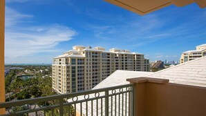 Un hotel moderno con numerosi balconi, una piscina e vista sullo skyline della città.