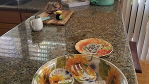 A kitchen counter with a decorative plate, a cutting board, and a jar of honey.