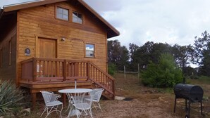A wooden cabin with a deck, outdoor seating, and a barbecue grill. - Glamping, off-grid adventure at peace-friendly cabin on 10 acres w/ STARGAZING! (Fredonia)