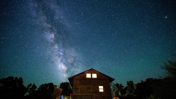 A wooden cabin with a balcony under a starry night sky. - Glamping, off-grid adventure at peace-friendly cabin on 10 acres w/ STARGAZING! (Fredonia)