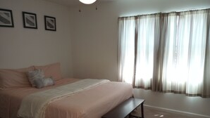 A bedroom with a bed, a bench, a rug, and a window with curtains. - Beautiful 3 Bedroom House Close To Richmond Raceway (Richmond)
