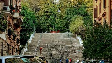 Une rue menant à un escalier, avec des voitures garées de part et d’autre.