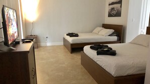 A hotel room with two beds, a desk with a TV, and a wall-mounted picture. - Home in Fort Lauderdale (Fort Lauderdale)