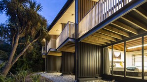 Un bâtiment moderne doté d’un balcon, de grandes fenêtres et offrant une vue sur le paysage environnant.