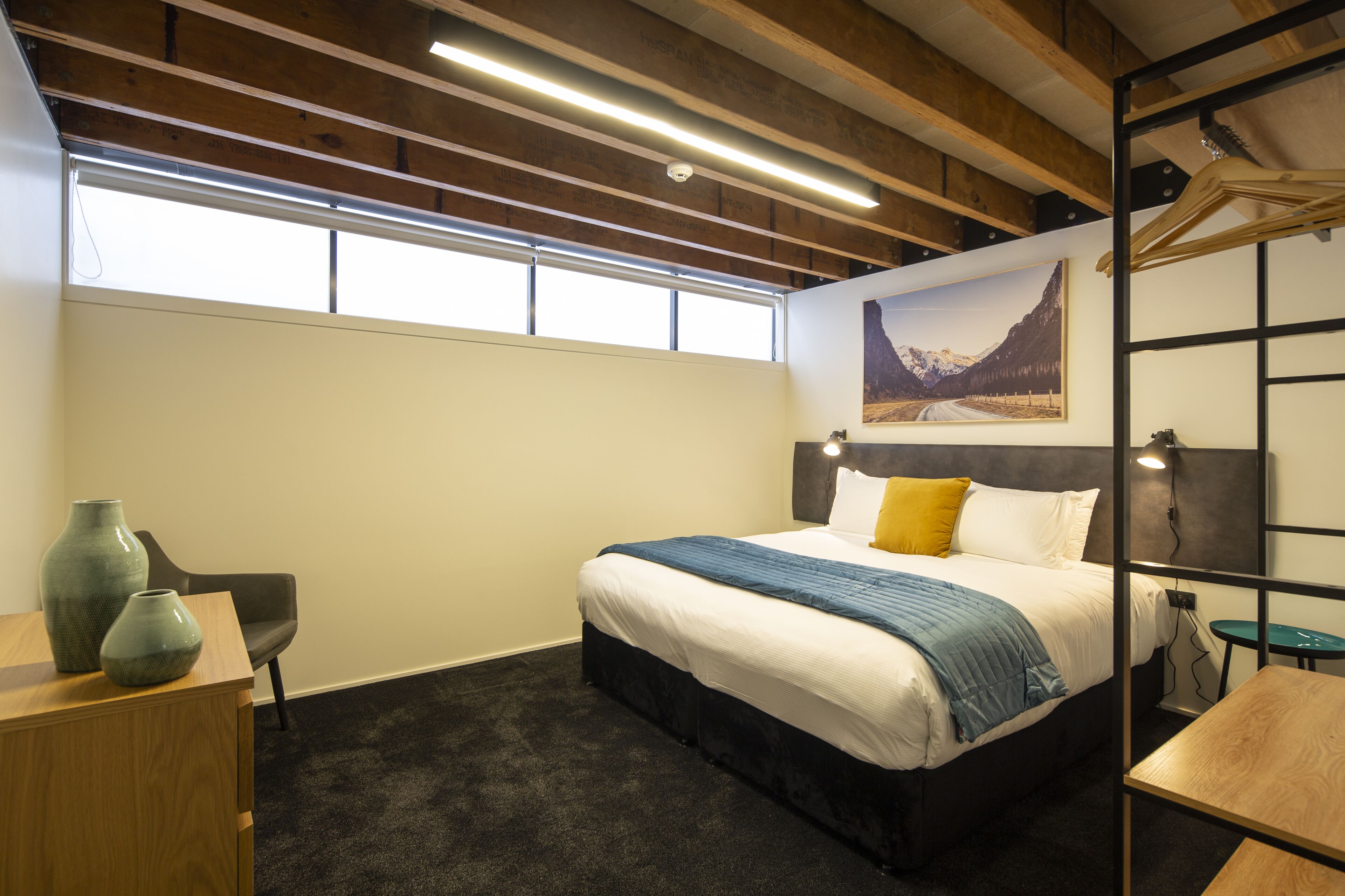 A modern bedroom with a bed, a desk, and a chair.