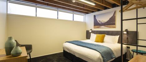 A modern bedroom with a bed, a desk, and a chair.