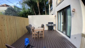 A wooden deck with a table and chairs, a grill, and a blue toy. - Huge House in Fort Lauderdale -  821 (Fort Lauderdale)