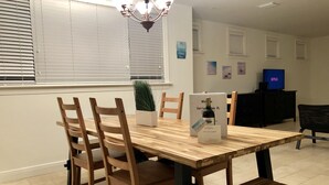A dining area with a wooden table, chairs, a potted plant, and a sign indicating a wine tasting event. - Huge House in Fort Lauderdale -  821 (Fort Lauderdale)