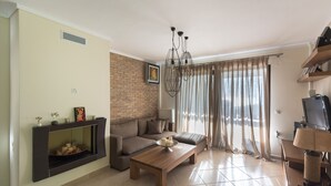 Ein Wohnzimmer mit Kamin, einer Couch, einem Couchtisch und einem Fernseher.