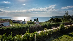 Ein Küstenwohngebiet mit Häusern, blauem Himmel und Blick auf das Meer.