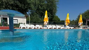A swimming pool with clear blue water, surrounded by white lounge chairs and yellow umbrellas. - Nehir Suit Hotel (Ortaca)
