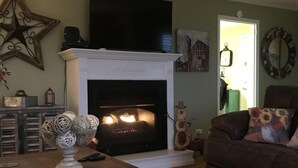 A living room with a fireplace, a large star decoration, a clock, and a couch. - OUR HOME ...AWAY FROM HOME (Laurel Springs)