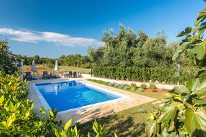 Una piscina al aire libre de temporada, sombrillas, tumbonas