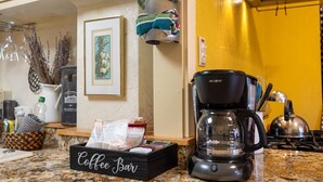 A kitchen counter with a coffee maker, a coffee bar sign, and various kitchen items. - Night Owl - Murphys Vacation Rentals (Murphys)