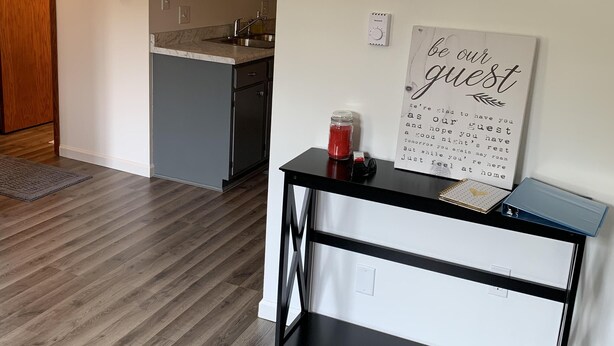 Una cocina moderna con armarios grises, un lavamanos de acero inoxidable y un horno empotrado.