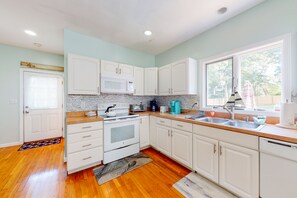 Enjoy cooking in this well-equipped kitchen with a stainless steel sink, microwave, and oven.